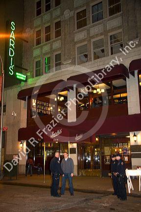Police officers question a man in front of Sardi's restaurant in the Theatre District of Manhattan, New York City, New York, USA.