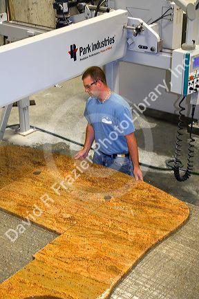 Worker custom cutting a granite countertop at the Shaker Hill Granite Company located in the town of Enfield, New Hampshire, USA.