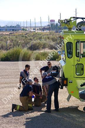 Firefighters taking direction from a training officer at an airport training facility in Boise, Idaho, USA.