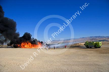 Firefighters using fire retardant foam to put out a jet fuel fire at an airport training facility in Boise, Idaho, USA.