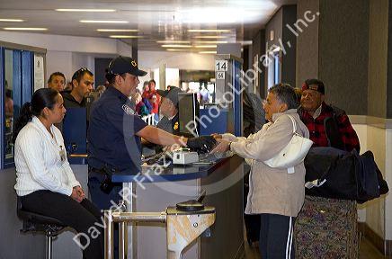 Pedestrians show identification and have their possesions searched to enter the United States port of entry at the Tijuana, Baja California, Mexico/San Diego, California border crossing.