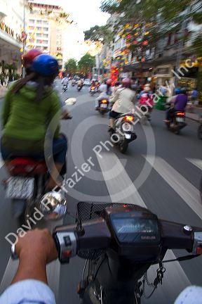 Vietnamese people ride motorbikes in Ho Chi Minh City, Vietnam.