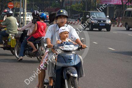 Vietnamese family riding motorbikes in Ho Chi Minh City, Vietnam.