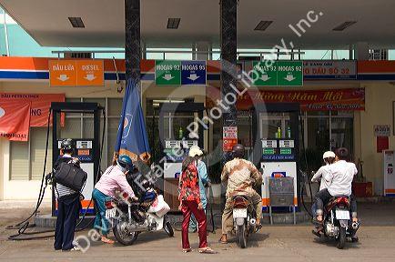 Vietnamese people fuel their motorbikes at a gas station in Ho Chi Minh City, Vietnam.