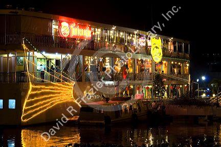 Floating restaurants on the Saigon River with lights at night in Ho Chi Minh City, Vietnam.