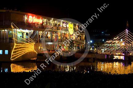 Floating restaurants on the Saigon River with lights at night in Ho Chi Minh City, Vietnam.