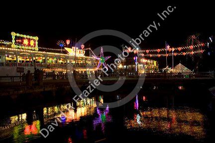Floating restaurants on the Saigon River with lights at night in Ho Chi Minh City, Vietnam.