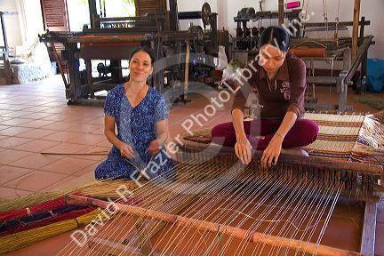Vietnamese women weaving mats at a craft factory in Hoi An, Vietnam.