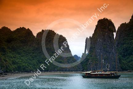 Scenic views of limestone karsts and tourist boats in Ha Long Bay, Vietnam.