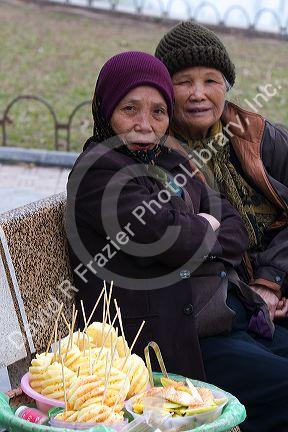 Vendors selling fruit on park benches along the Hoan Kiem Lake in Hanoi, Vietnam.