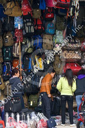Vendors selling bags and luggage on the street in Hanoi, Vietnam.