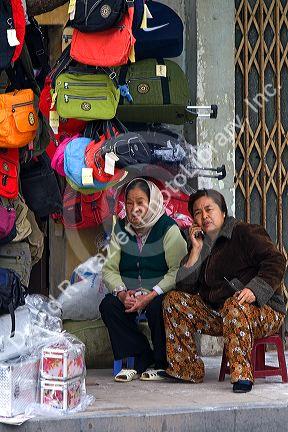 Vendors selling bags and luggage on the street in Hanoi, Vietnam.