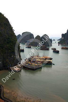 Scenic views of limestone karsts and tourist boats in Ha Long Bay, Vietnam.