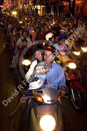Vietnamese people ride motorbikes on Dong Khoi street during the last night of Tet Lunar New Year celebrations in Ho Chi Minh City, Vietnam.
