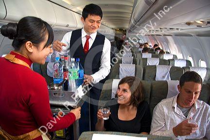 Flight attendents serve beverages to passengers on a Vietnamese airliner.
