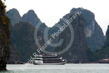 Scenic views of limestone isles and boats in Ha Long Bay, Vietnam.
