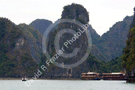Scenic views of limestone isles and boats in Ha Long Bay, Vietnam.
