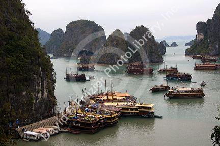 Scenic views of limestone karsts and tourist boats in Ha Long Bay, Vietnam.