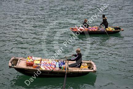Vendors in boats selling snack food to tourists in Ha Long Bay, Vietnam.