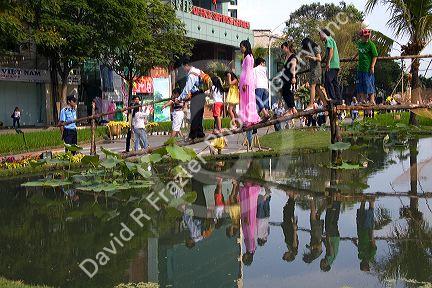 People walk across a small footbridge during Tet Lunar New Year celebrations in Ho Chi Minh City, Vietnam.