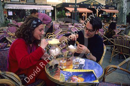 French couple eating ice cream at an outdoor cafe in Avignon, France.