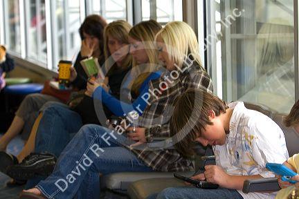 Boys playing with a personal video game system at the Boise Airport, Idaho, USA.