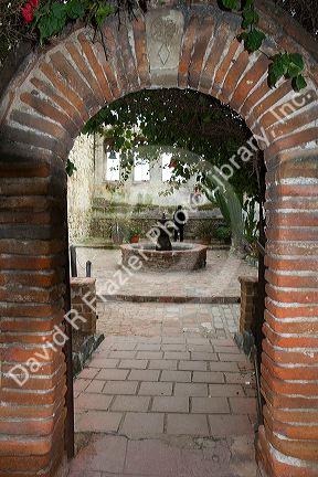 Arched entrance to the Sacred Garden at the Mission San Juan Capistrano, California, USA.