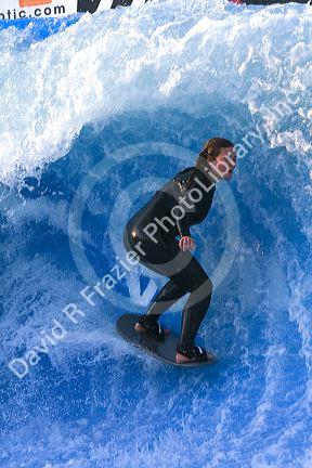 Woman surfing on a man made wave machine at Mission Beach, San Diego, Southern California, USA. MR