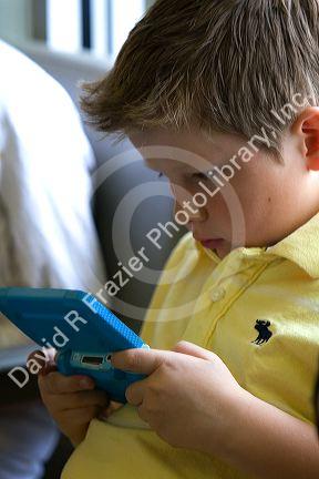 Boy playing with a personal video game system at the Boise Airport, Idaho, USA. MR
