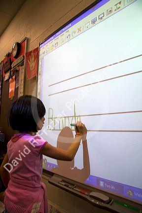 Kindergarten students use an interactive whiteboard in the classroom of a public school in Boise, Idaho, USA. MR
