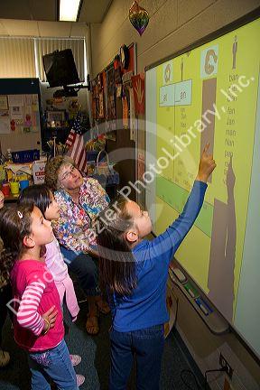 Kindergarten students use an interactive whiteboard in the classroom of a public school in Boise, Idaho, USA. MR