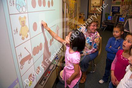 Kindergarten students use an interactive whiteboard in the classroom of a public school in Boise, Idaho, USA. MR