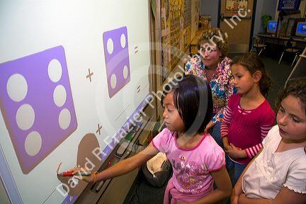 Kindergarten students use an interactive whiteboard in the classroom of a public school in Boise, Idaho, USA. MR