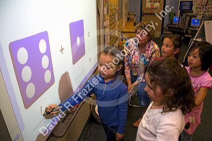 Kindergarten students use an interactive whiteboard in the classroom of a public school in Boise, Idaho, USA. MR