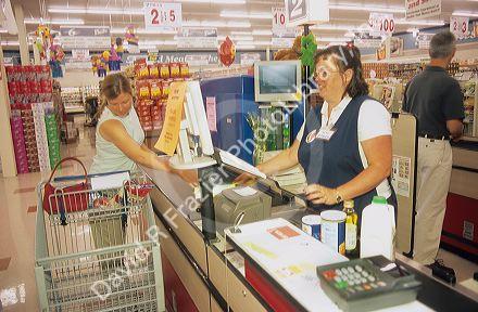 Woman customer checking out at the grocery store.