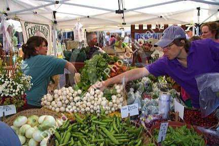Customers purchase fresh vegetables from a farmers market in Boise, Idaho, USA.
