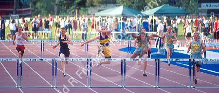 Male high school students racing in a hurdles track event.  Boise, Idaho.