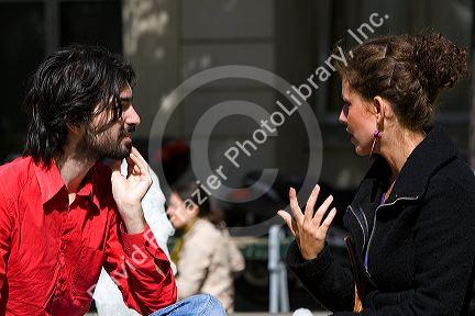 French man and woman have a conversation near the Sorbonne in Paris, France.