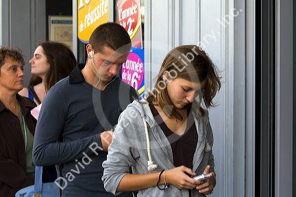 French female student viewing images on a digital camera in the Latin Quarter of Paris, France.