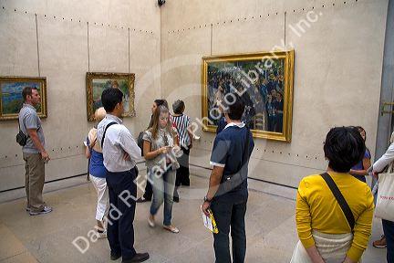 Visitors view artwork displayed in the Musee d'Orsay, Paris, France.
