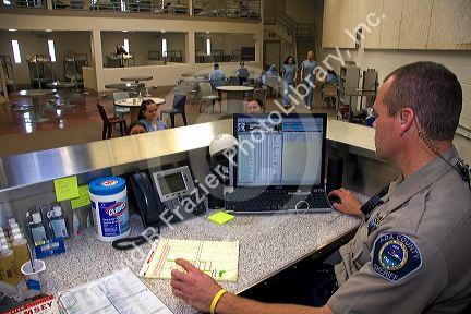 Security officer monitoring the female inmate dormatory of a county jail.