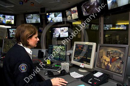 Jail security control room with female officer using video monitors and remotely controlls doors.