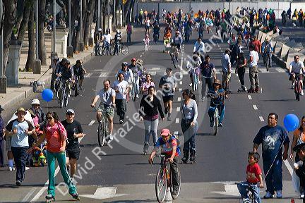 Pedestrians and bicyclists traveling on the Paseo de la Reforma on a Sunday in Mexico City, Mexico.