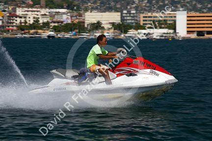 Man riding a personal watercraft in Acapulco Bay, Acapulco, Guerrero, Mexico.