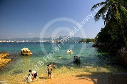 People swim in the bay at Island Roqueta, Acapulco, Guerrero, Mexico.