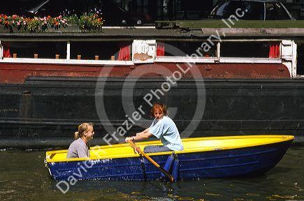 Women in a row boat on a canal in Amsterdam.