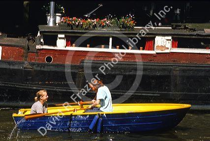 Women in a row boat on a canal in Amsterdam.