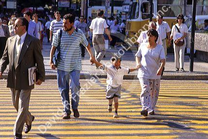 Parents hold their childs hand while crossing the street in Santiago, Chile.