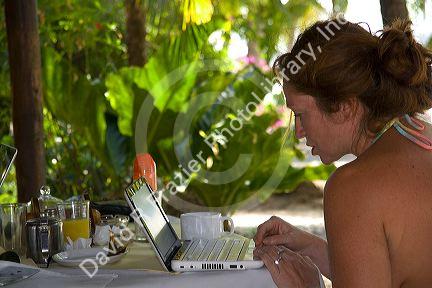 Woman using a laptop computer at a resort near Samara, Costa Rica.
