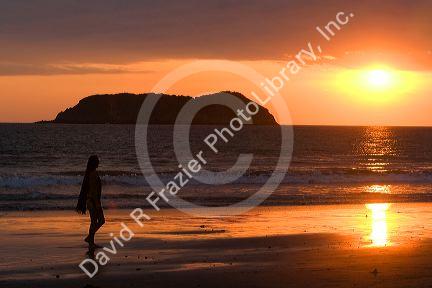 Person walking on the beach at sunset in the Manuel Antonio National Park in Puntarenas province, Costa Rica.